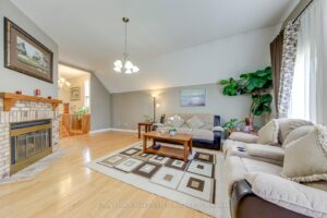 Family room featuring gas fireplace, hardwood floors and open layout overlooking the foyer.
