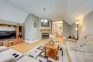 Alternate view of the spacious family room with fireplace and hardwood flooring.