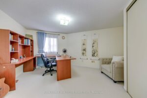 Home office or fourth bedroom with built-in desk, shelving and large closet.