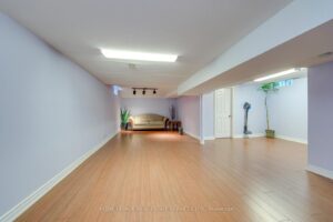 Finished basement recreation room with laminate flooring and flexible open-concept layout.