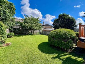 Large, fully fenced backyard with mature trees, manicured lawn and landscaped gardens at 3364 Ingram Rd., Mississauga.