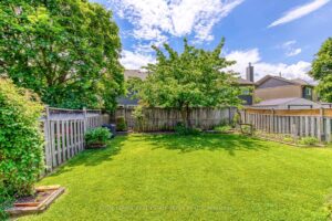 Expansive private backyard with mature shade tree, lush lawn and garden beds at 3364 Ingram Rd.