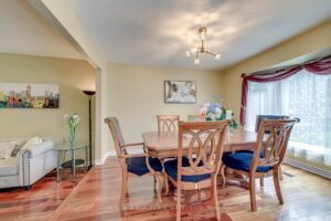 Formal dining room with hardwood floors, large picture window and modern chandelier at 3364 Ingram Rd.