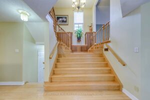 Grand split-level foyer with hardwood staircase, soaring ceiling and open landing.