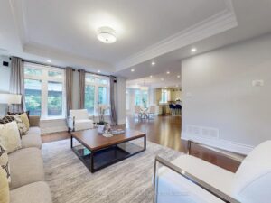 Elegant living room with expansive windows and seamless flow to the dining area.