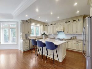 Gourmet kitchen with oversized island, custom cabinetry, and stainless steel appliances.