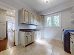 Functional laundry room with custom cabinetry, folding counter, and utility sink.