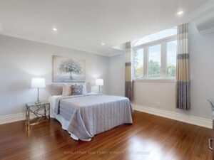 Bright secondary bedroom with hardwood flooring, large window, and neutral décor.