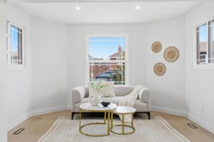 Comfortable sitting area in the primary suite featuring large windows, neutral décor and abundant natural light.