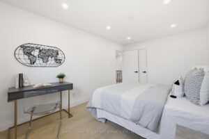 Bright secondary bedroom with hardwood flooring, workspace and modern finishes.