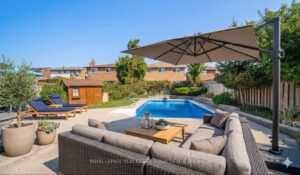 Private backyard oasis with in-ground swimming pool, spacious patio, outdoor lounge seating and mature landscaping.