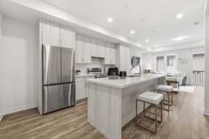 Modern kitchen with quartz island, stainless steel appliances, breakfast seating and ample cabinetry.