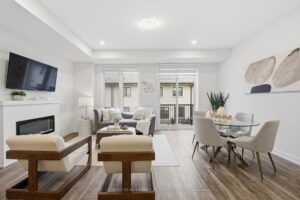 Open-concept living and dining room with fireplace, balcony access and stylish contemporary finishes.