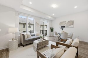 Bright open-concept living and dining area with large windows, balcony access and abundant natural light.