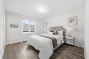 Spacious second bedroom with large window, neutral décor and contemporary finishes.