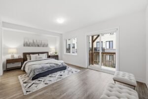 Spacious primary bedroom with private balcony access, large windows and generous floor space.
