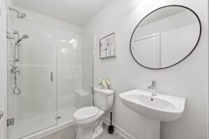 Modern bathroom featuring a glass walk-in shower, pedestal sink and contemporary fixtures.