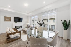 Dining area overlooking the living room with large windows, balcony access and abundant natural light.