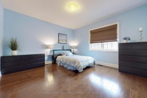 Bright secondary bedroom with hardwood flooring, large window, and neutral décor.
