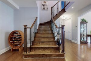 Grand front foyer with curved hardwood staircase and elegant double-door entry.