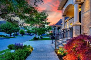 Twilight view of the landscaped front walkway leading to the luxury home's entrance.
