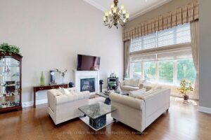 Spacious formal living room with oversized windows, chandelier, and abundant natural light.