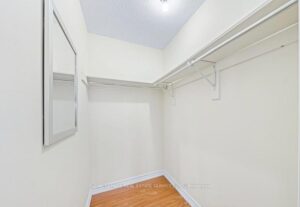 Walk-in closet with custom shelving and hanging storage.