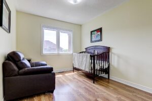 Spacious secondary bedroom with hardwood flooring and large window.