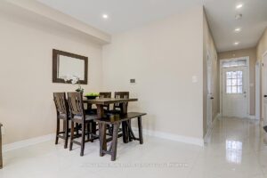 Dining area with contemporary lighting and open view toward the front foyer.