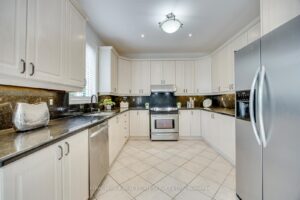 Modern kitchen at 2249 Glazebrook, Mississauga, featuring granite countertops, stainless steel appliances, and abundant cabinetry.
