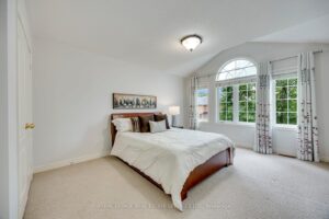 Spacious bedroom at 2249 Glazebrook, Mississauga, with vaulted ceilings, oversized arched windows, and abundant natural light.