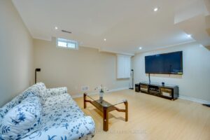 Finished basement media room at 2249 Glazebrook, Mississauga, featuring a spacious entertainment area and large wall-mounted TV.