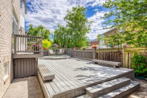 Expansive backyard deck at 2249 Glazebrook, Mississauga, offering multiple seating areas and mature surrounding trees.