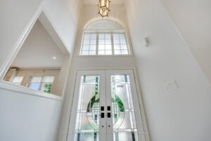 Grand two-storey foyer at 2249 Glazebrook, Mississauga, featuring soaring ceilings, double entry doors, and an oversized arched window.