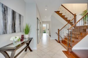 Main hallway at 2249 Glazebrook, Mississauga, featuring a hardwood staircase with iron pickets and an open-concept design.