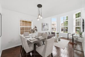 Bright formal dining room with large windows, hardwood flooring, and contemporary lighting.