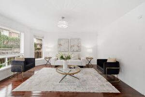 Spacious family room with hardwood flooring, fireplace, and large front window.