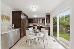 Eat-in kitchen with dark wood cabinetry, breakfast area, and walkout to the backyard.