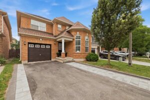 Front exterior of a two-storey brick home with double garage and landscaped driveway.