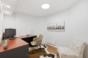 Basement office with desk, seating area, and finished living space.