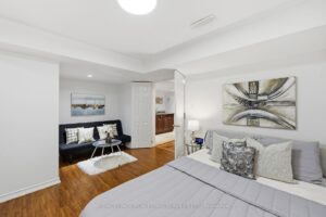 Finished bedroom with adjacent seating area and modern finishes.