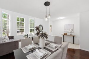 Open-concept dining and living area with abundant natural light and hardwood flooring.