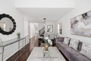 Spacious foyer with hardwood flooring, staircase, and open sightlines to the living area.