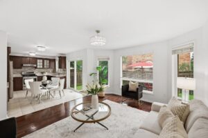 Bright family room with large windows and open-concept connection to the kitchen.