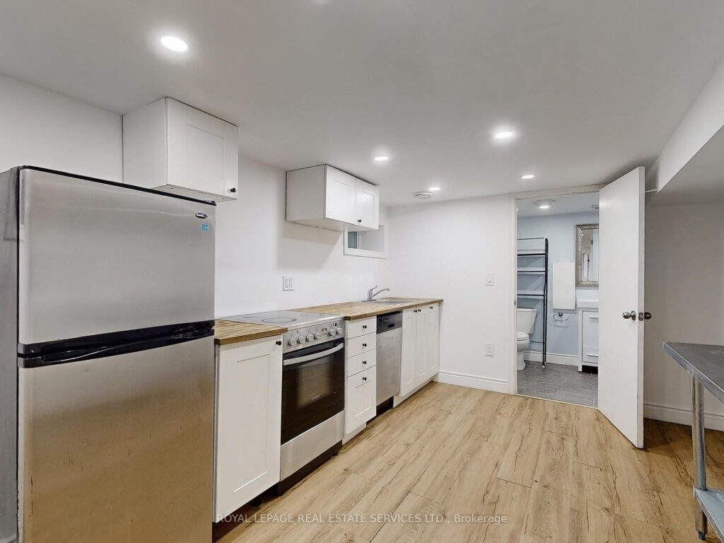 Bright modern kitchen with quartz countertops, stainless steel appliances, and light wood flooring.