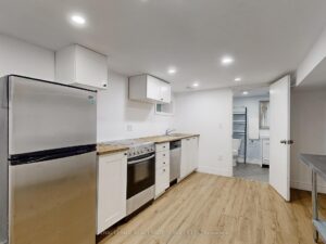 Bright modern kitchen with quartz countertops, stainless steel appliances, and light wood flooring.