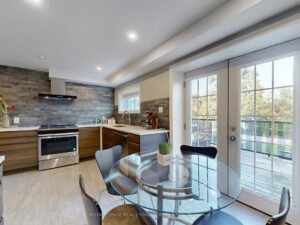 Dining area overlooking the backyard with patio doors and open-concept kitchen.