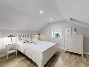 Loft bedroom featuring vaulted ceilings, recessed lighting, and abundant natural light.