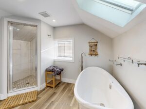 Spa-inspired bathroom with freestanding soaker tub, skylight, and glass shower.