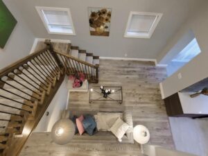 Dramatic two-storey foyer with hardwood staircase and open view from above.
